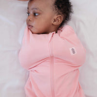 Baby in dreamy days pink swaddle on white linen