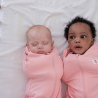 Two babies wearing dreamy days pink dream swaddle
