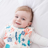 Toddler wearing the Dreamy Days ocean themed dream sack on white bed