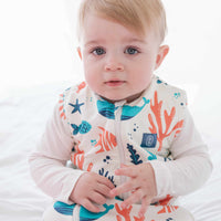 Baby and toddler wearing the Dreamy Days ocean themed dream sack on white bed