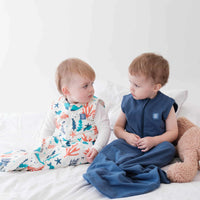 Two Baby and toddler wearing the Dreamy Days navy and ocean themed dream sack on white bed