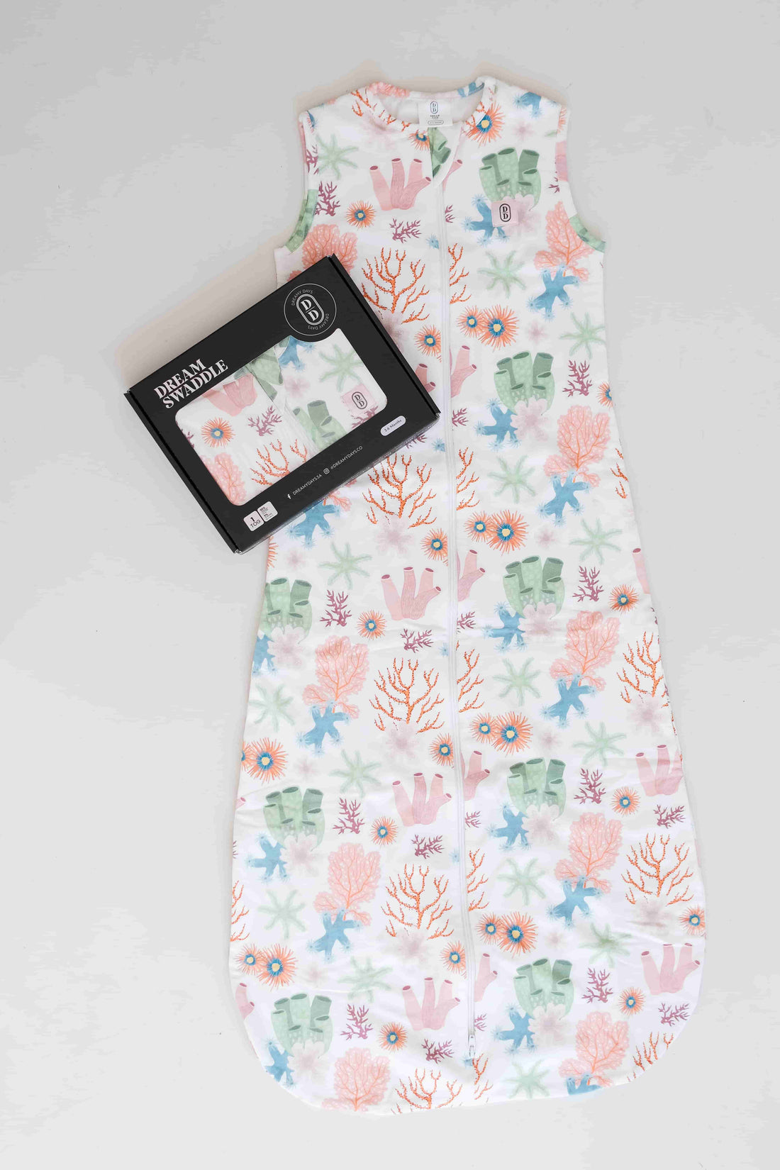 Dreamy days baby dream swaddle pink coral with black packaging on white surface