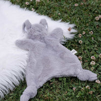 Dreamy Days Grey mouse plush toy on a white fur rug lying on grass.