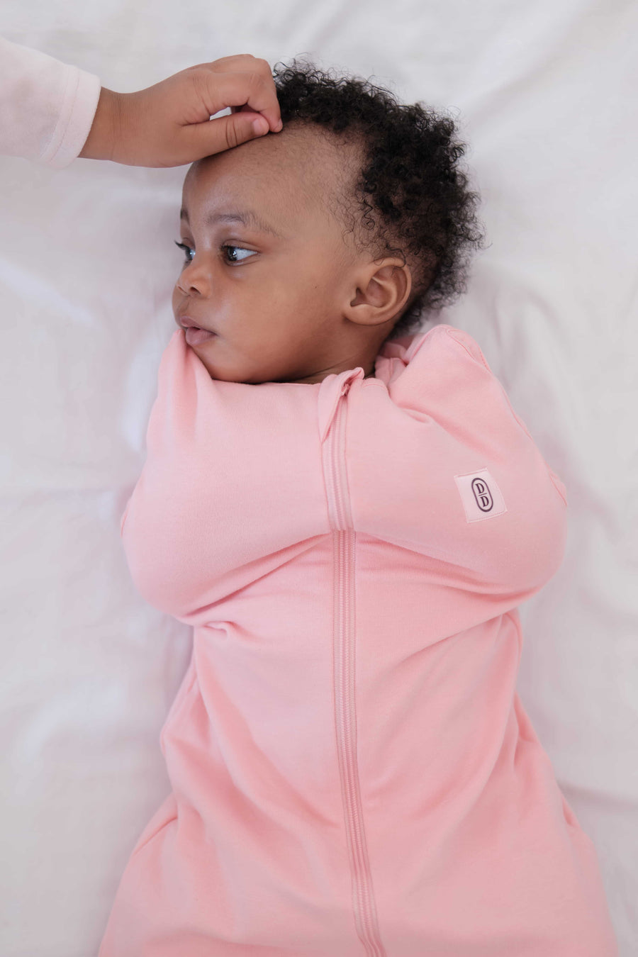 Baby in dreamy days pink swaddle on white linen