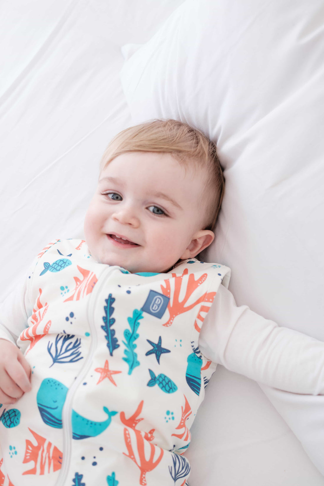 Toddler wearing the Dreamy Days ocean themed dream sack on white bed