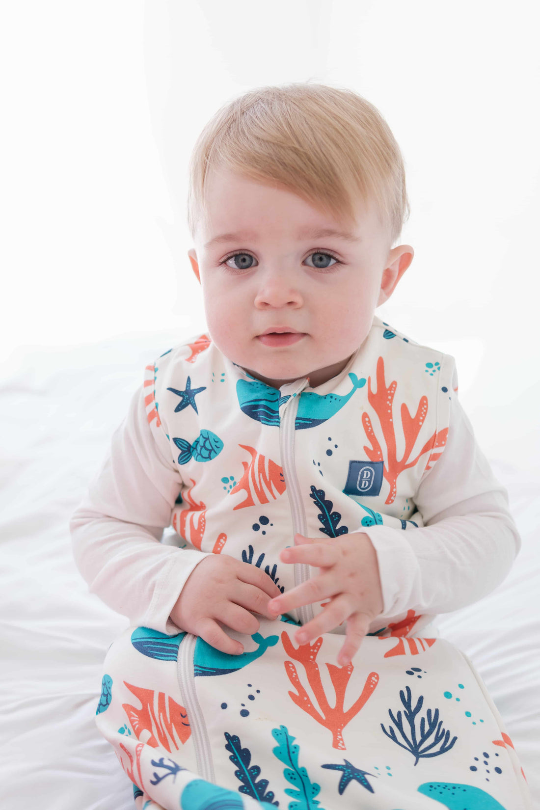 Baby and toddler wearing the Dreamy Days ocean themed dream sack on white bed