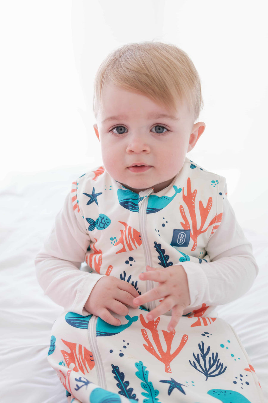 Baby and toddler wearing the Dreamy Days ocean themed dream sack on white bed