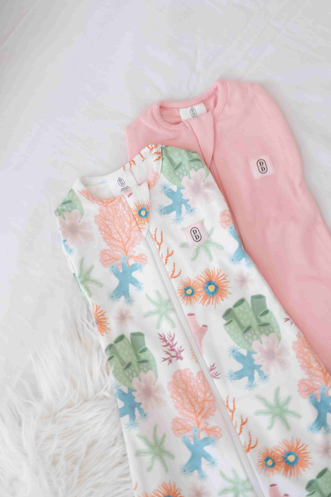Dreamy days baby dream swaddle pink and coral on white surface