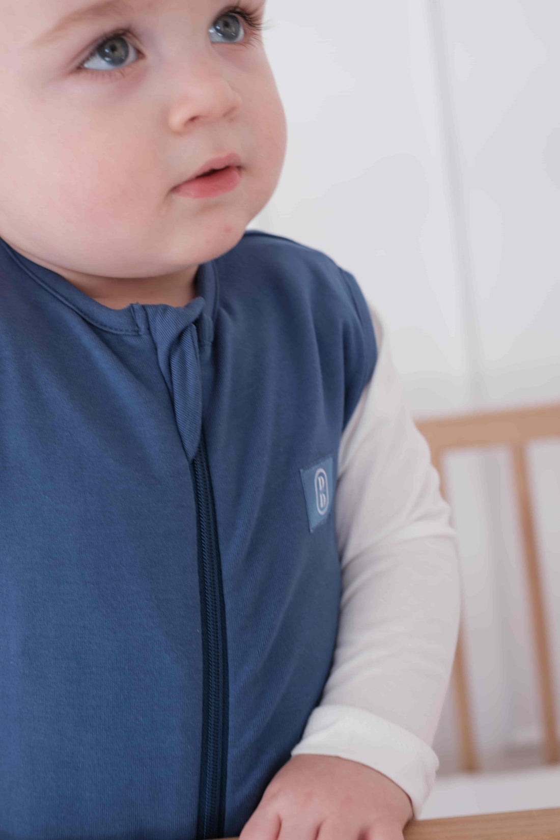 Toddler wearing a dreamy days navy dream sack in cot