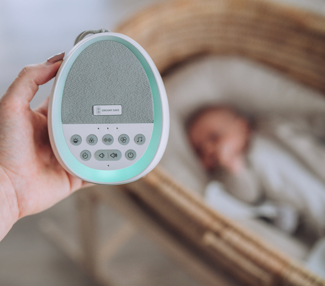 Mother holding Dream Pod baby white noise machine and night light